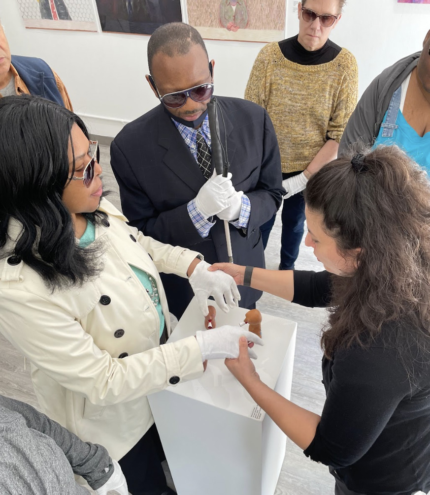 A small group of individuals with low vision enjoying a hands-on art gallery experience at Twelve Gates Arts in Philadelphia.