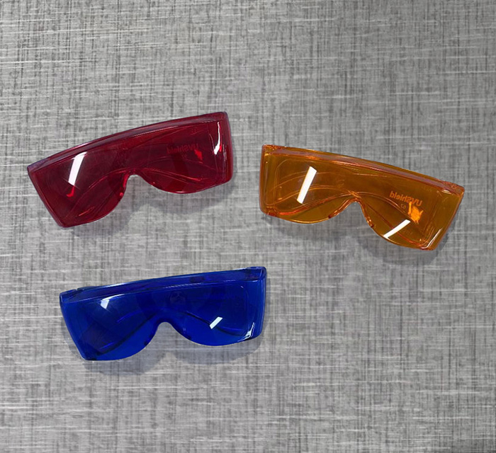 An arrangement of three color-tinted glasses in red, orange, and blue.