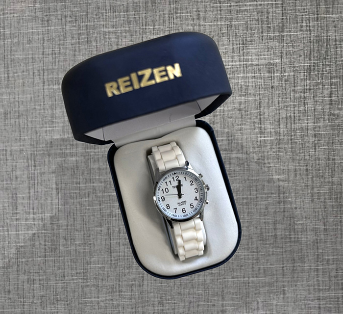 A photo of a white talking watch in a blue case.