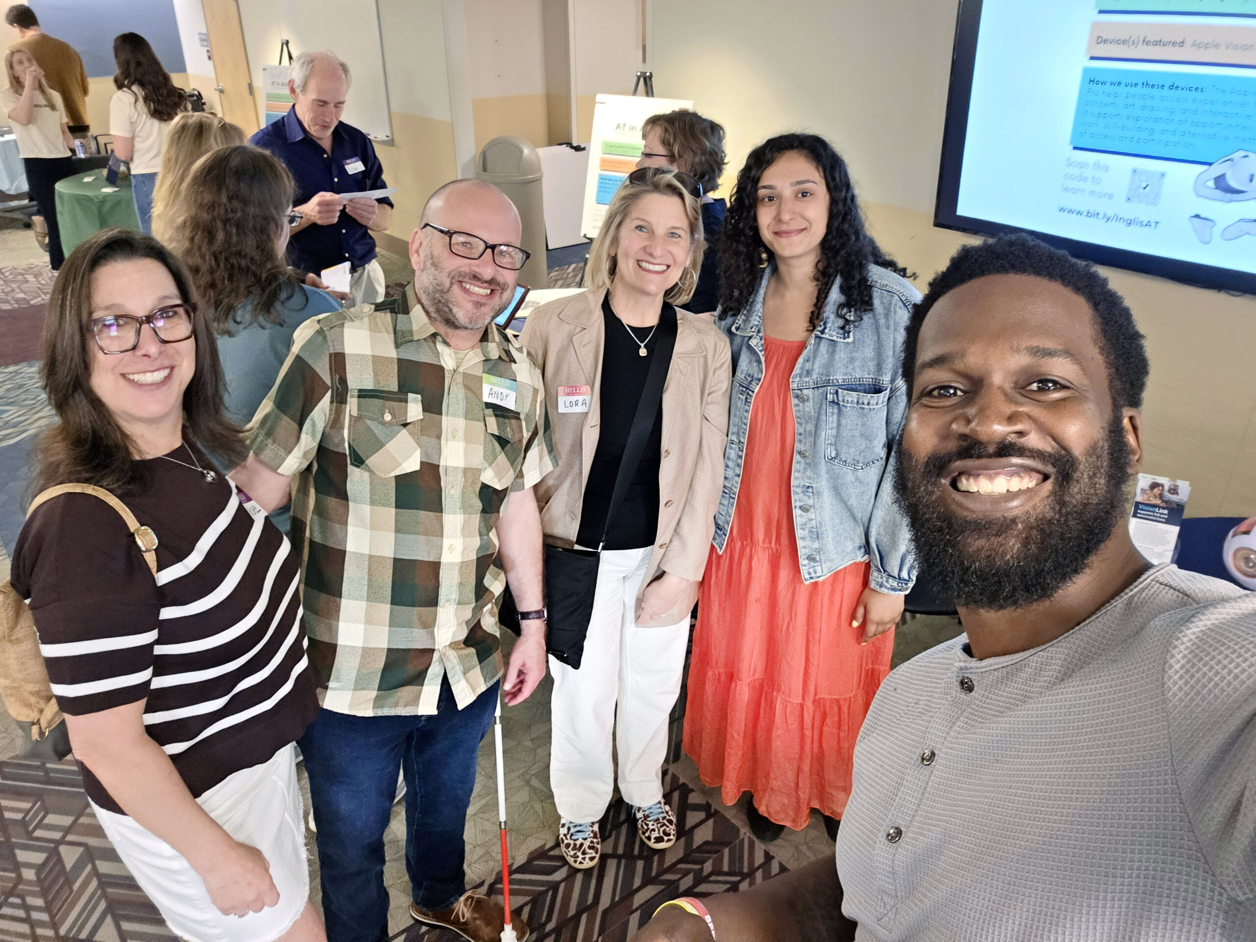 A VisionLink staff member poses with attendees at the Inglis Assistive Technology in Action Conference.