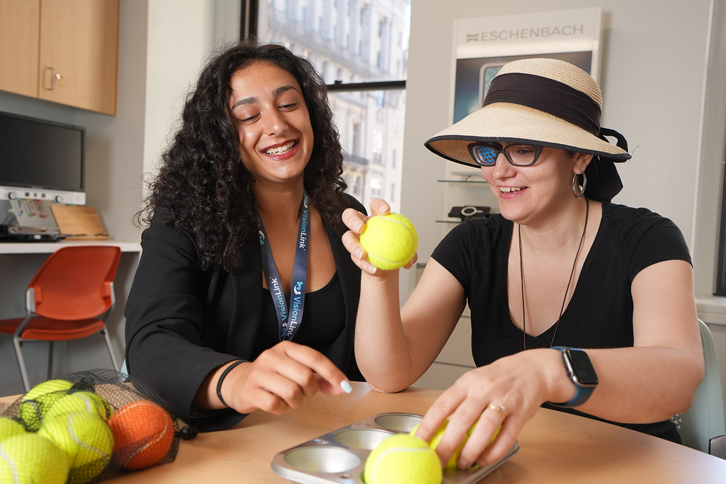 Vision rehabilitation therapist Sofiya Zilberberg works with a client who is practicing setting tennis balls into a muffin tin.